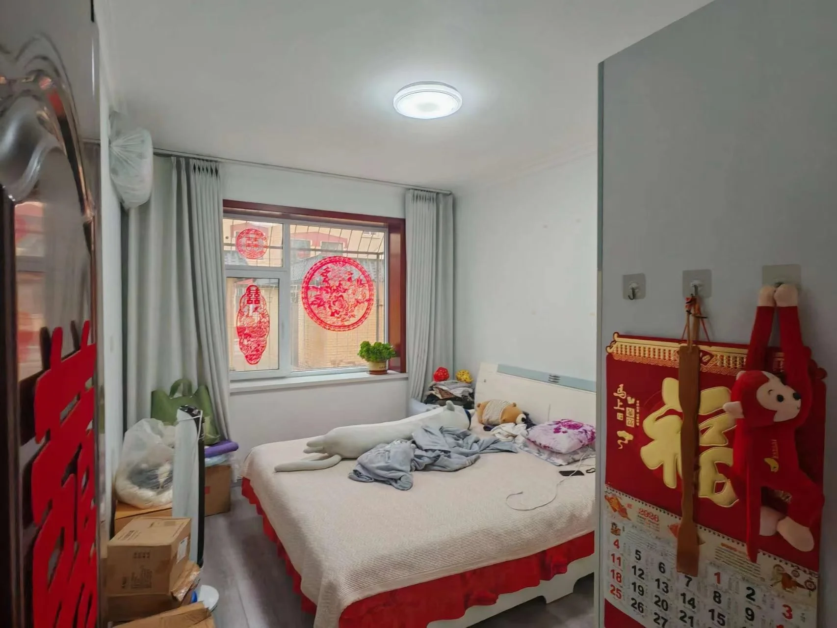 卧室空间，床铺占据中心位置，搭配简单的床品和窗帘。房间采光适中，整体装修风格偏基础实用型。