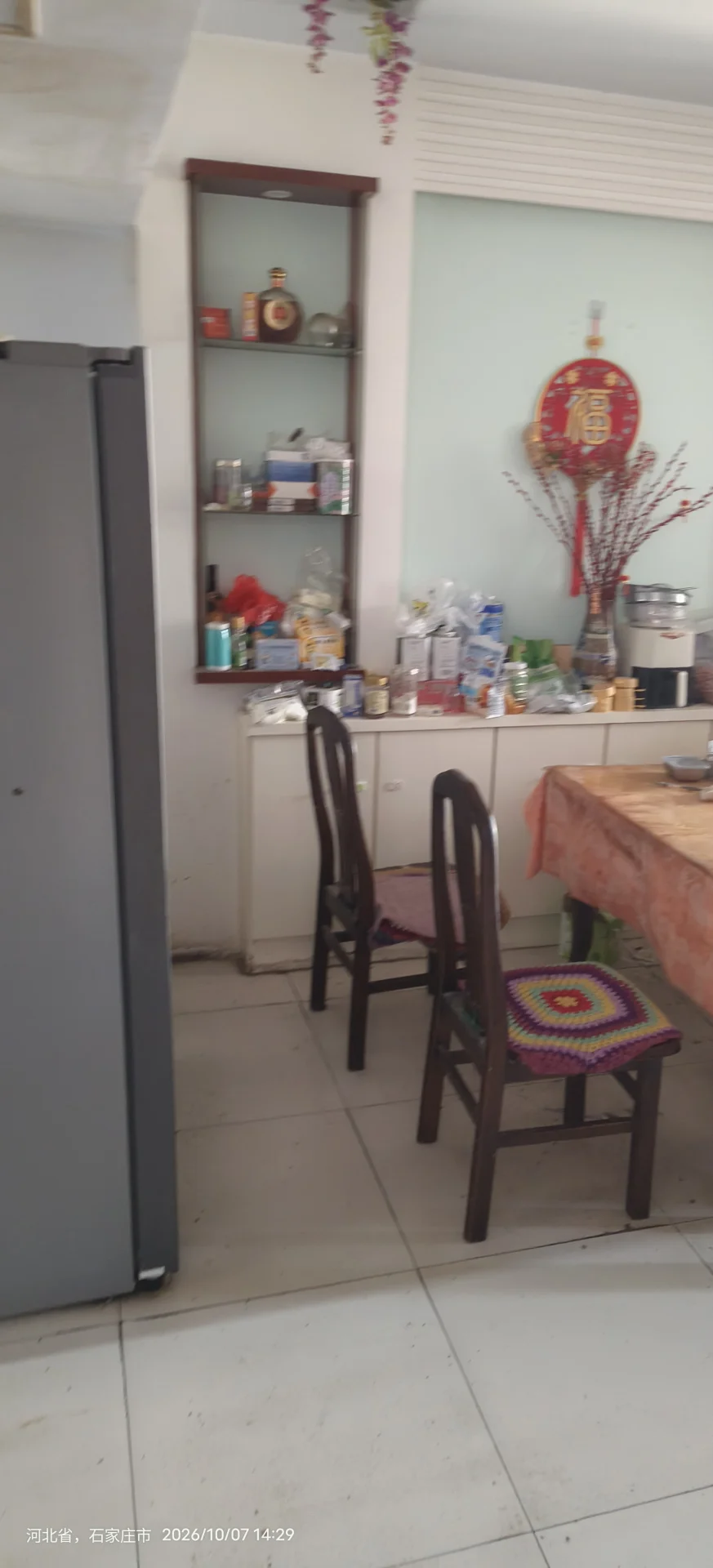 厨房空间，墙面和地面采用浅色瓷砖铺设，配有嵌入式储物柜和操作台。整体环境简洁明亮，具备基础的厨房功能设施。