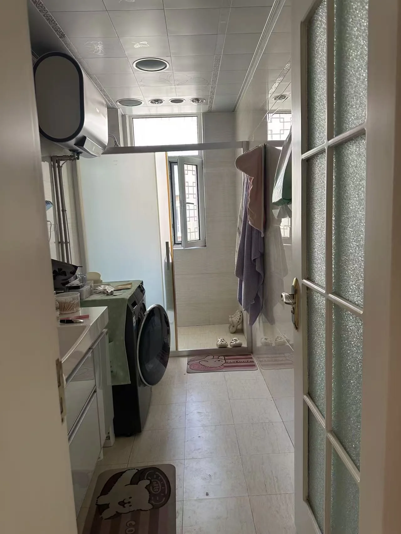 洗衣房空间，配备了洗衣机和烘干机等家电，地面铺设浅色瓷砖。空间采光适中，整体环境实用且整洁。