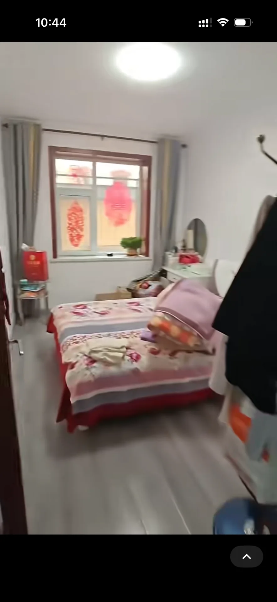 卧室空间，铺设浅色木纹地板，房间内摆放着两张双人床，床品色彩鲜艳。采光良好，整体环境简洁明亮。