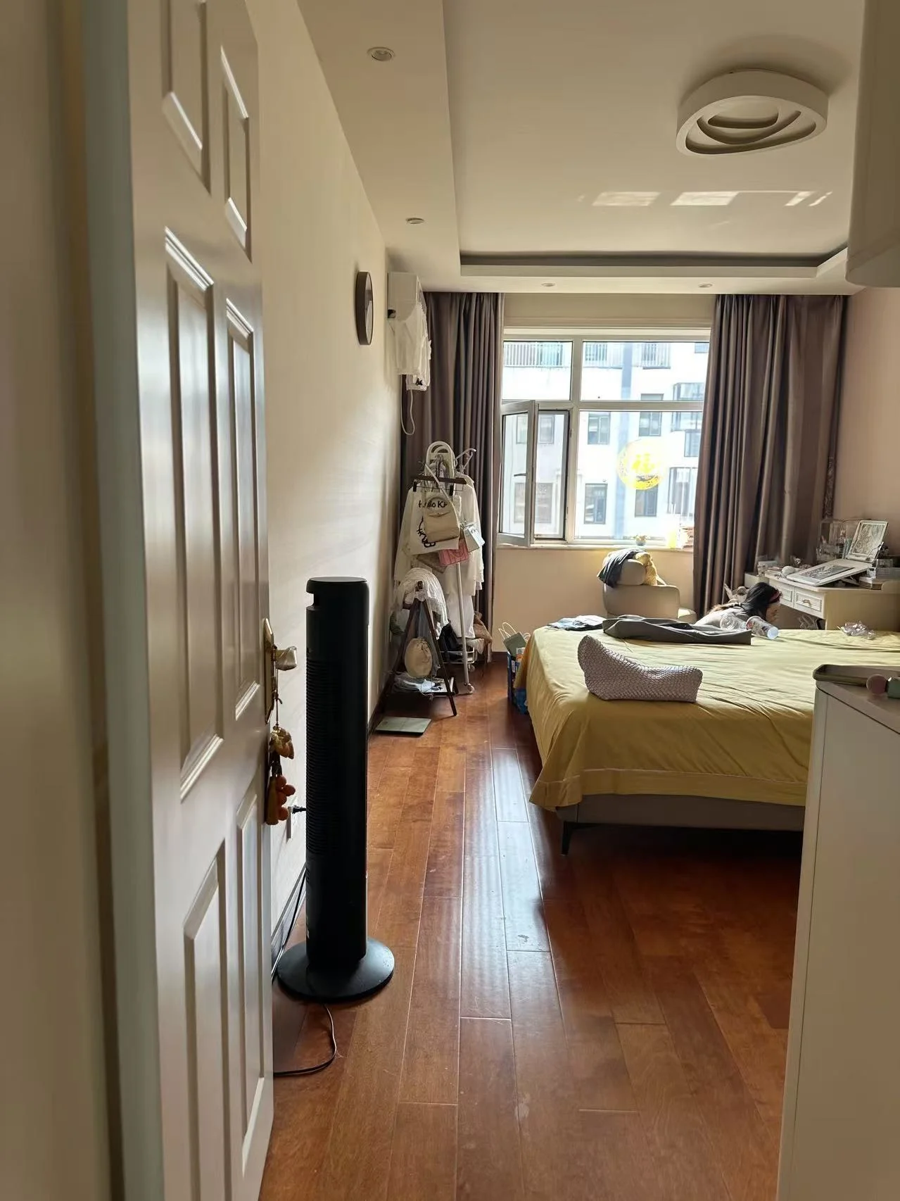 卧室空间，地面铺设木纹地板，配有床和衣柜等基础家具。房间采光适中，整体装修风格偏向实用简约，环境整洁。