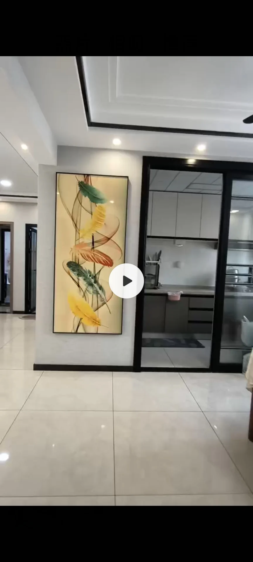这是一个宽敞的室内空间，地面铺设浅色瓷砖，墙面简洁，配有一幅大型抽象艺术画作为视觉焦点。空间采光良好，整体呈现现代简约风格。