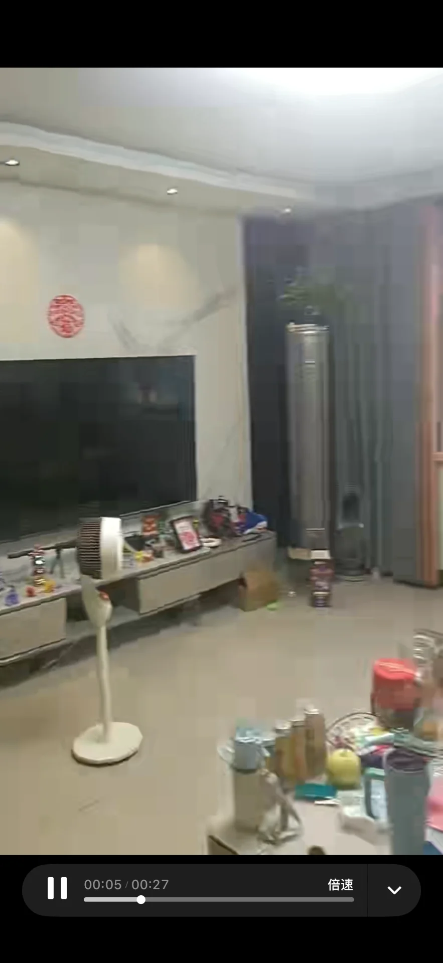 室内空间，地面为浅色瓷砖，墙面简洁，配有大型电视和展示柜。整体环境光线均匀，呈现出基础的商业或展示空间特征。