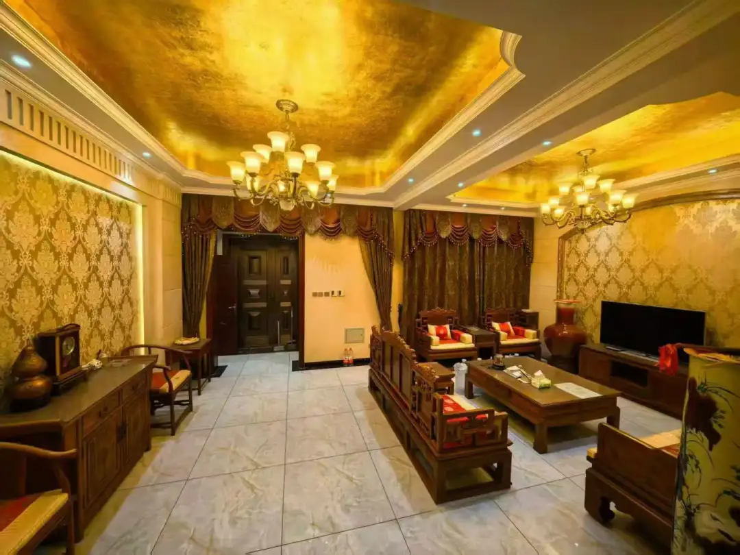 这个宽敞的起居室拥有高天花板和金色的墙壁，充满了现代感和光线，营造出一个放松和社交的理想环境。关键字:关键词：起居室 现代感 光线